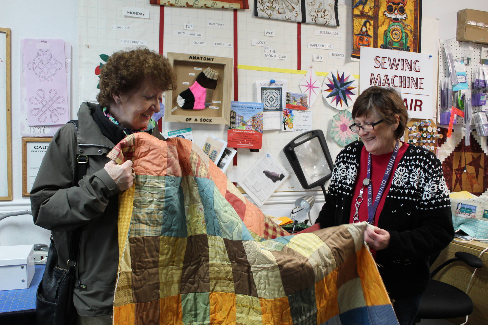 Photo by Karina Andrew/Whidbey News-Times
Maura Whittaker, left, was finally allowed to return to the U.S. to retrieve a quilt she had dropped off with Debra Staley at the Quilters Workshop before the pandemic. Whittaker made the quilt out of fabric from a book of upholstery and curtain samples.