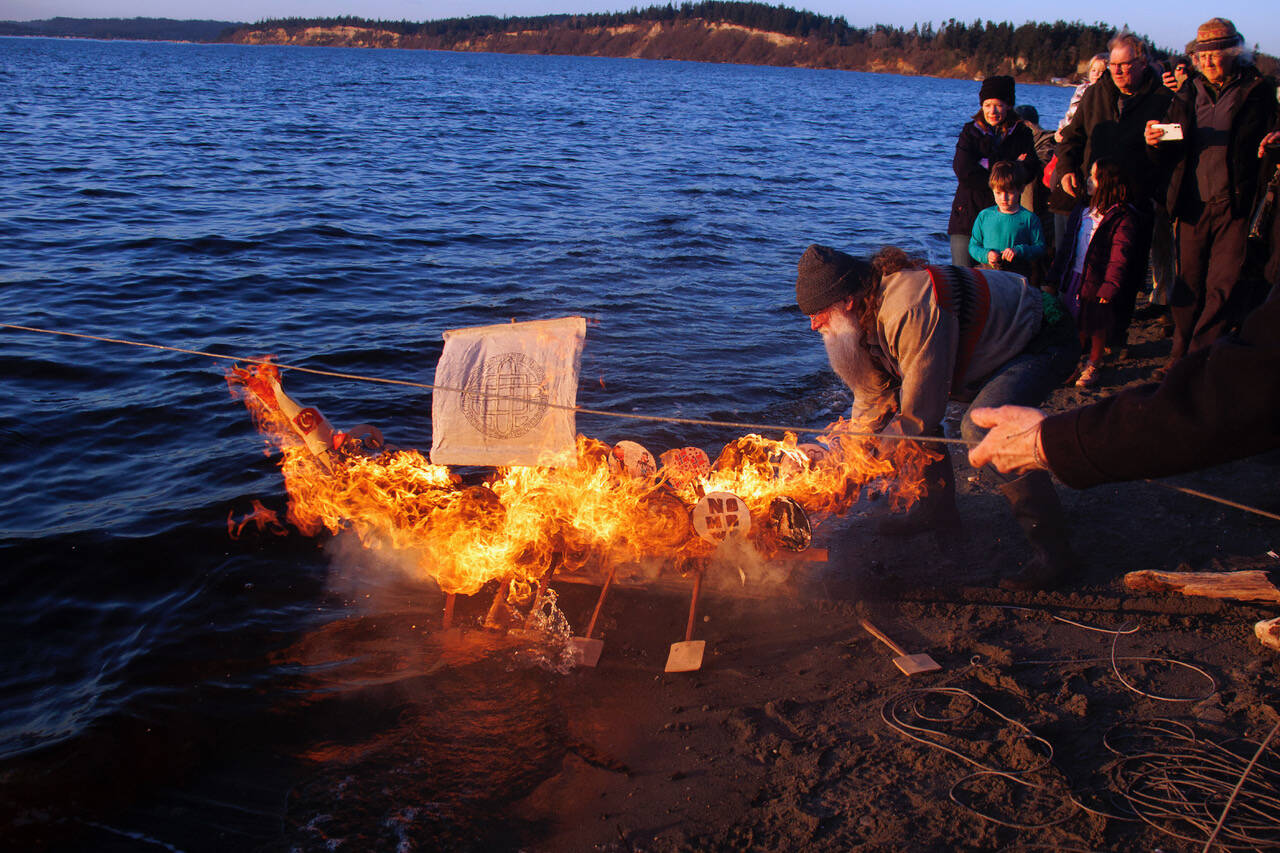 Photo by David Welton
Michael Clyburn sets afloat a blazing Viking-style ship he built to honor the late Peter Hansen. On the second anniversary of Hansen’s passing, friends and family members gathered to remember the colorful South Whidbey resident.