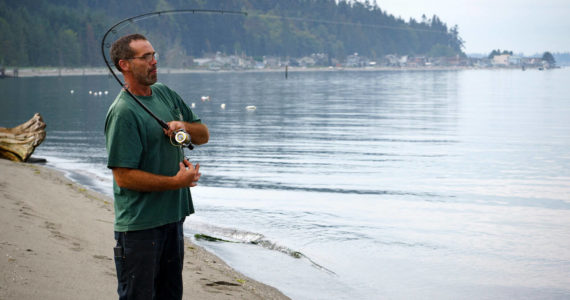 Photo by David Welton
Langley resident Gary Reeves reels in a fish at Robinson Beach in Freeland, near where the closed Mutiny Bay boat ramp is located.