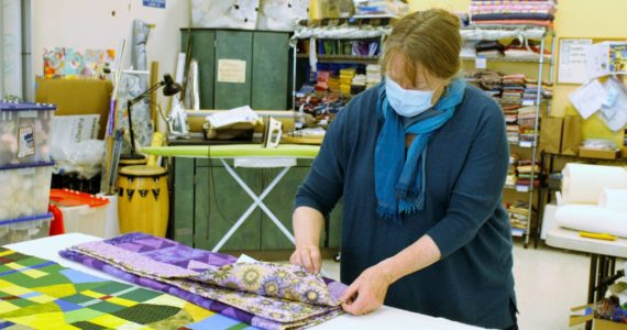 File photo/South Whidbey Record
Luanne Seymour, photographed here in 2021, shows a few different-sized quilts that Whidbey Blanket Makers sewed. The group continues to meet at Create Space.