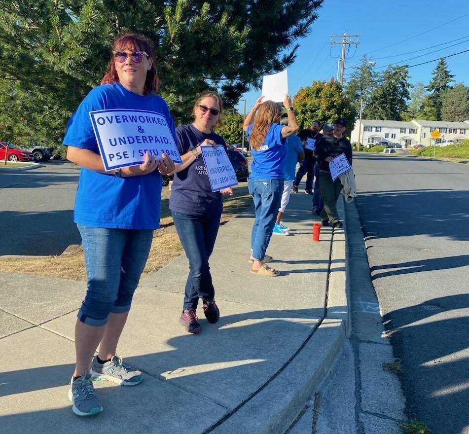 Photo provided
Members of PSE 821 wave signs in support of the union’s negotiating team outside of North Whidbey Middle School during a bargaining session Sept. 14.