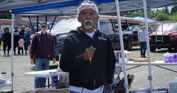 Tony Cladusbid, co-owner of the Beaver Tales Coffee franchise, announces the canoe races at the Penn Cove Water Festival on Saturday. (Photo by Sam Fletcher)