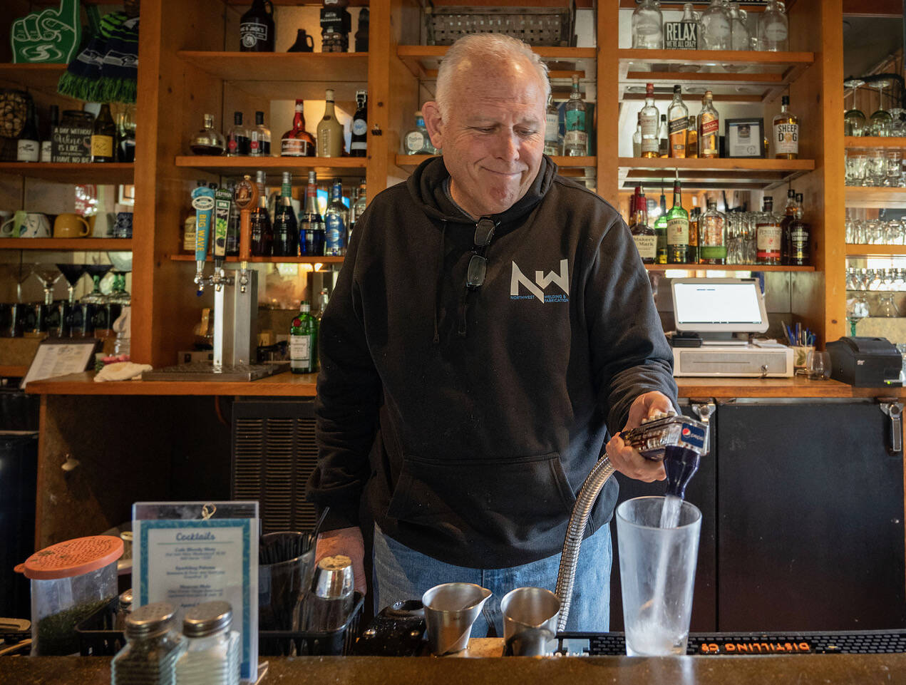 Jeff Kennelly serves a drink in the bar of the Freeland Cafe. (Photo by David Welton)