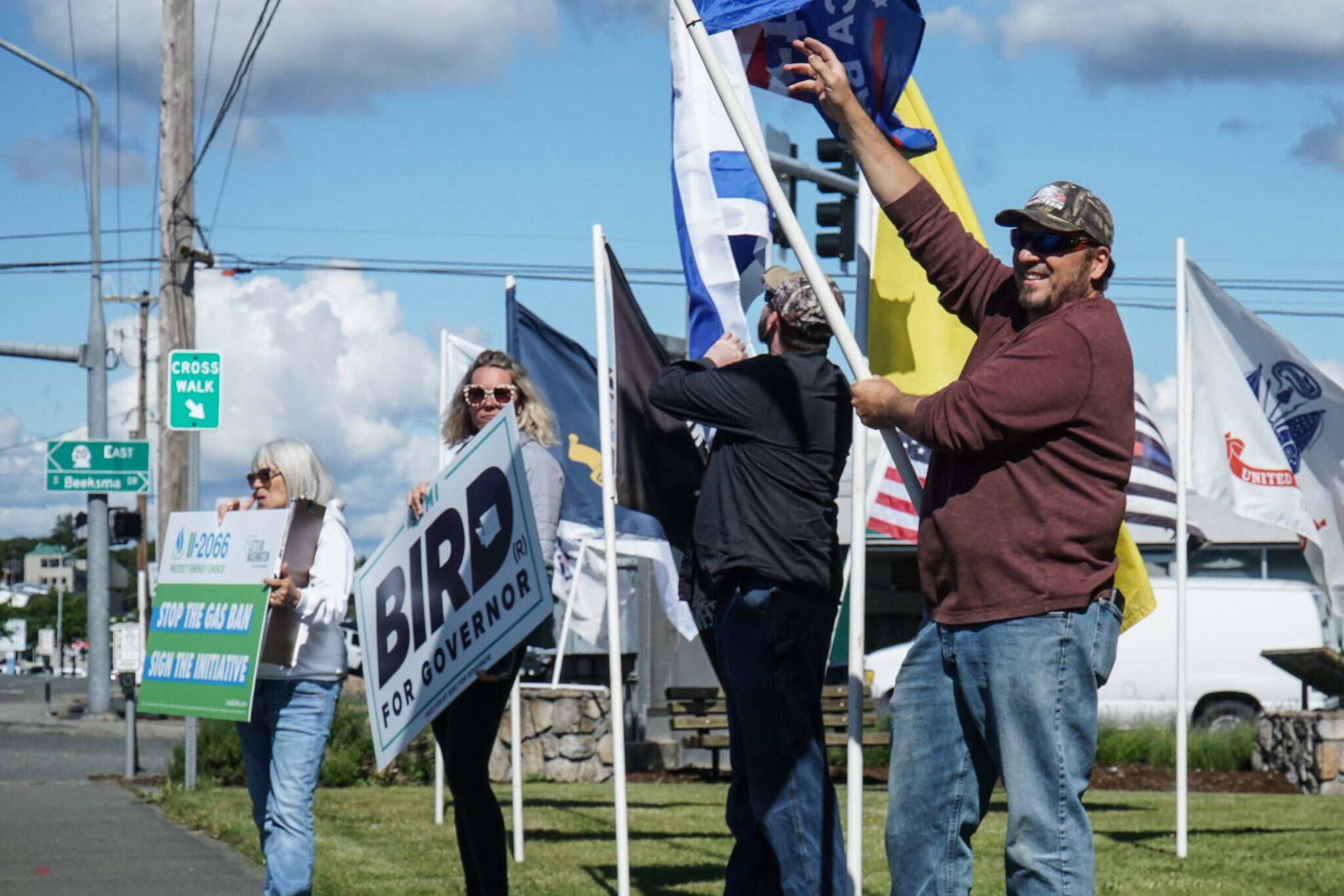 Island County Republican Party President Tim Hazelo (right) rallies with others in Oak Harbor on Thursday. (Photo by Sam Fletcher)