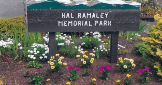 A former sign of Hal Ramaley Memorial Park rises above flowers. (Photo provided)