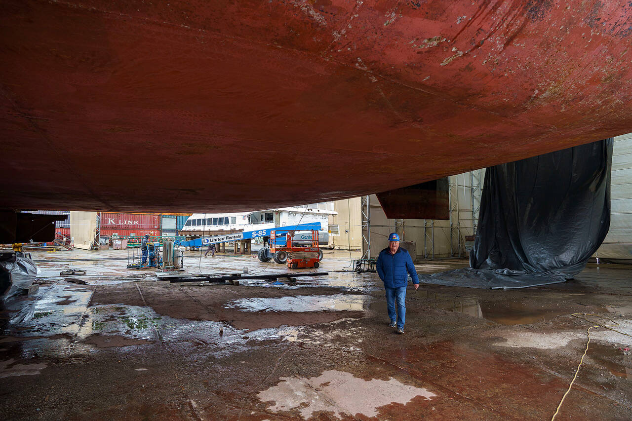 Photo by David Welton
Matt Nichols walks beneath the giant hull of a boat during an event at the Freeland boat company years ago.
