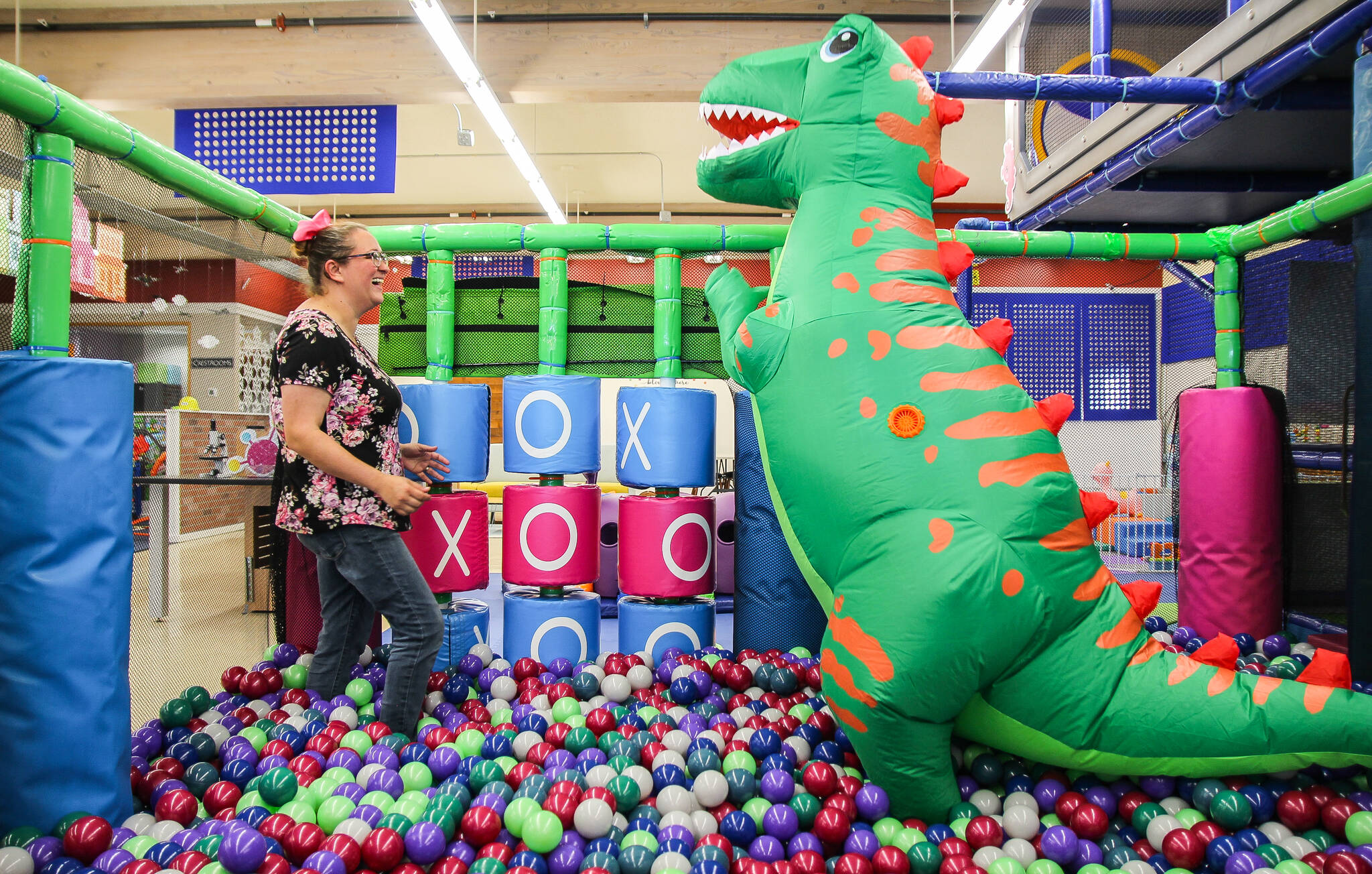 Jaylynn Sybrant plays tic tac toe with a dinosaur in the ball pit. (Photo by Luisa Loi)