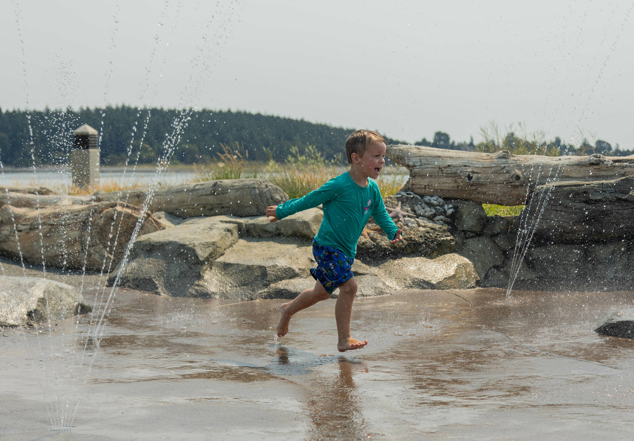 Tanner Marchant, 7, of Oak Harbor plays on the splash pad in Windjammer Park. (Photo by Caitlyn Anderson)