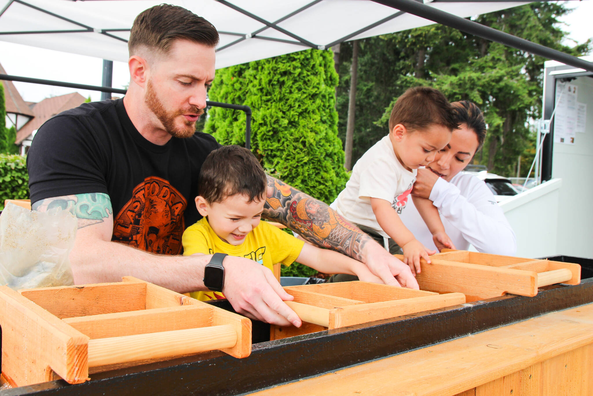 From left, Joe, Orion, Yessi and Jason “Squish” Dunegan sift sand in the sluice box to find hidden treasures. (Photo by Luisa Loi)