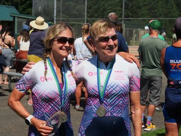 Following completion of the July 20 Whidbey Island Triathlon, Brenda Lovie, left, and Sandi Lusk enjoy their first place medals, won for competing in their age division. (Photo provided)