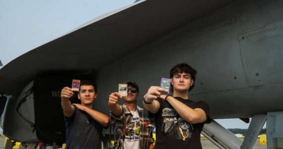 Left to right: Ty Johnon, Aiden Pieste and Cash Crites display Yu-Gi-Oh cards before a growler at Naval Air Station Whidbey Island on Saturday. (Photo by Sam Fletcher)