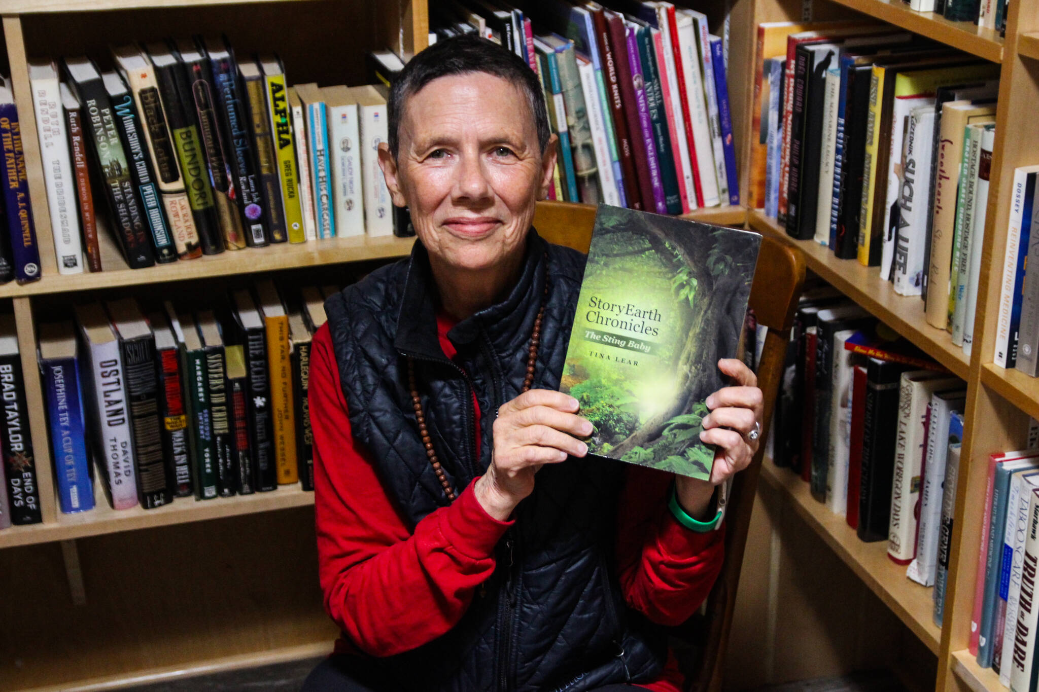 Tina Lear holds a copy of her debut novel “StoryEarth Chronicles: The Sting Baby” at the Kingfisher Bookstore. (Photo by Luisa Loi)