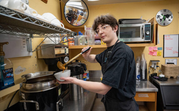 Brody Ehling ladles some creamy tomato basil soup in the kitchen of the South Whidbey Commons. (Photo by David Welton)