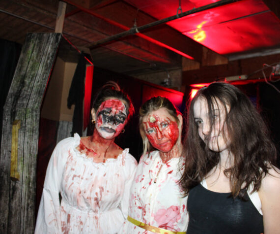 Scare actors from left: Savannah Gomez, Evelyn Vice and Miley Dutton pose at Twisted Manor at the Oak Harbor Roller Barn. (Photo by Sam Fletcher)