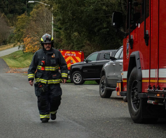 A Central Whidbey Firefighter returns to his engine. (Photo by Sam Fletcher)