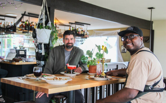 Co-Owners Sedrick Livingston, at right, and Tyler Hansen enjoy a meal at Goldie's and The Roost, a restaurant they opened with Sophia Jones.