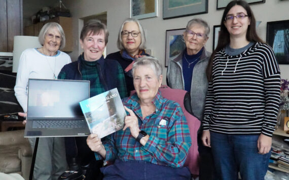 Photo by Sam Fletcher
Whidbey Writers Group poses with its newest release, “Whidbey Island: An Insider’s Guide” on Tuesday.