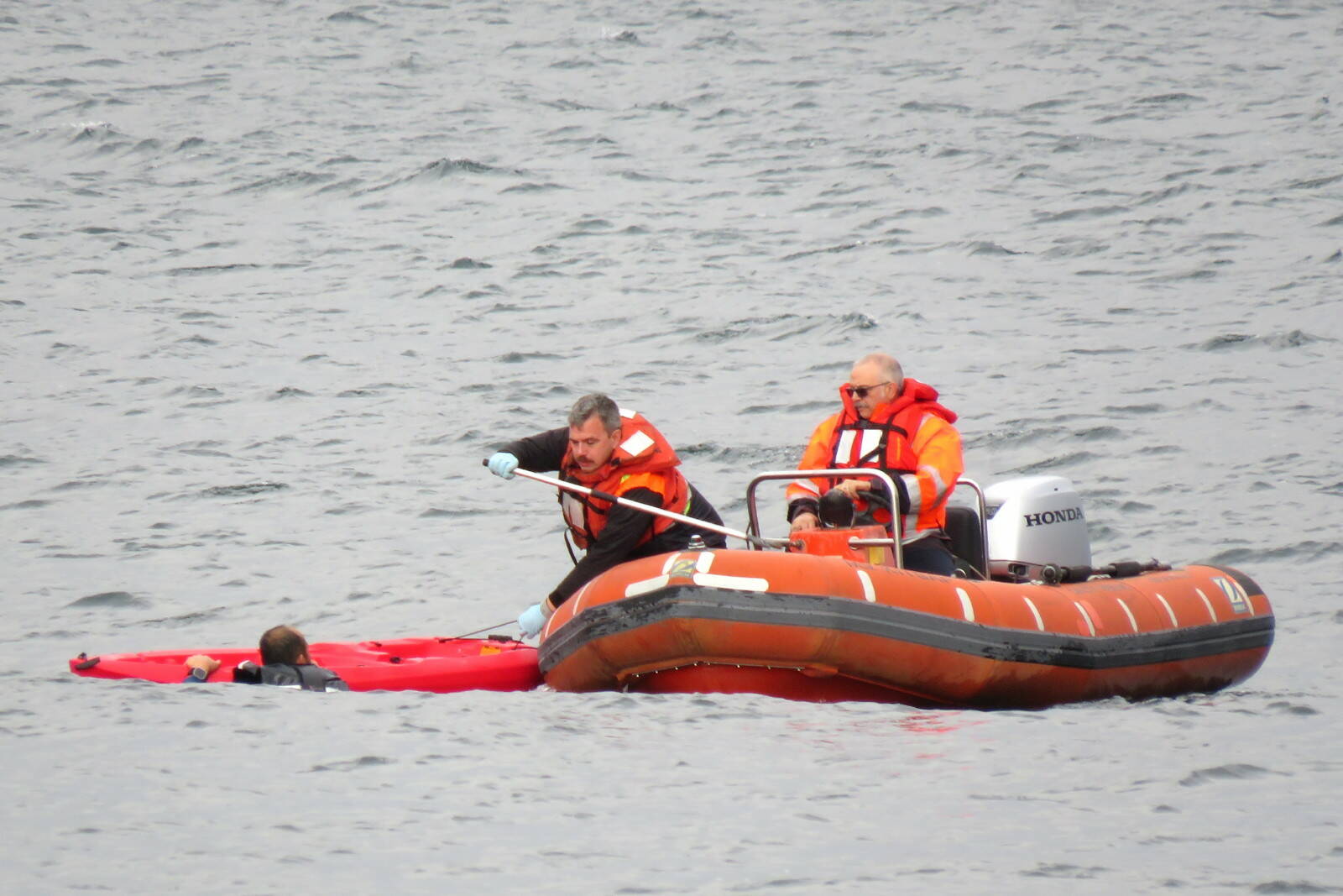 Photo provided
Washington State Ferries crew members help a kayaker in distress climb aboard their rescue vessel Sunday.