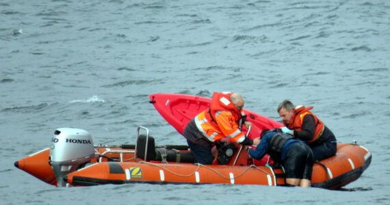 Photo provided
Washington State Ferries crew members help a kayaker in distress climb aboard their rescue vessel Sunday.