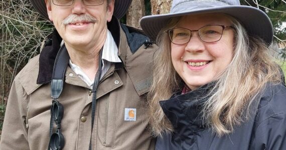 Steve and Martha Ellis stand near a Whidbey forest. (Photo by Beth Stephens)