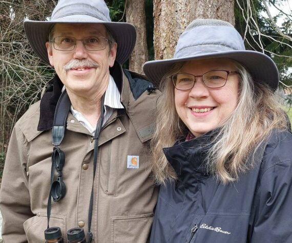 Steve and Martha Ellis stand near a Whidbey forest. (Photo by Beth Stephens)