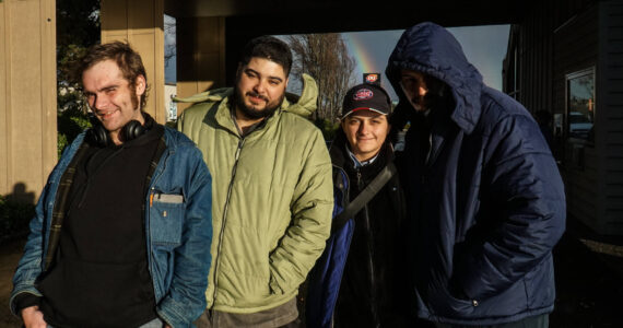 Nick Coloso (left), Phoenix Welch (middle-right) and other patrons of the SPIN Cafe await meals on Friday. (Photo by Sam Fletcher)