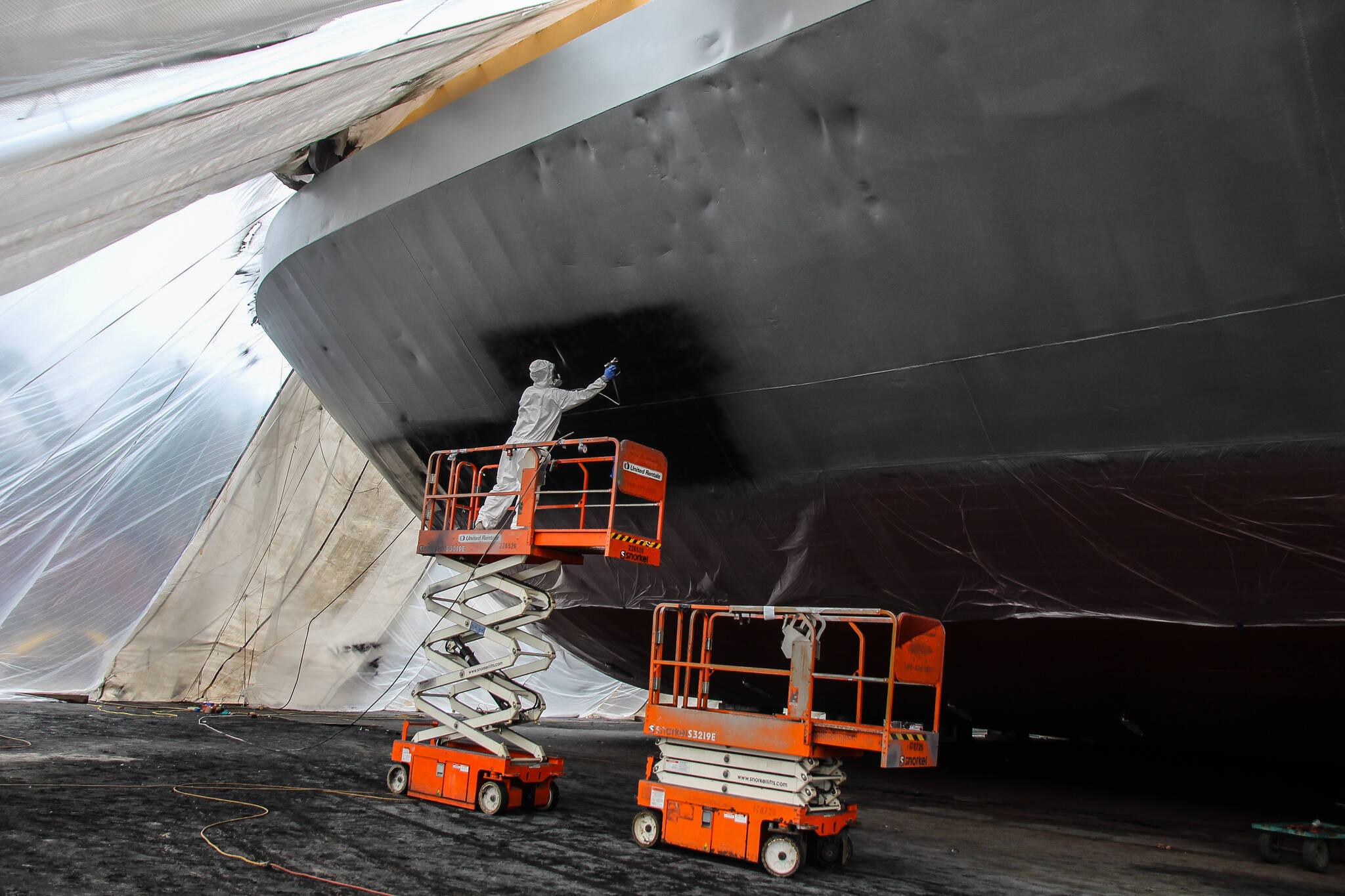 Photo by Luisa Loi
Tyler Allen, also known as “peanut” by his coworkers, paints the Madison Bay on a Tuesday morning. The boat is about 17 feet tall from the bottom to the main deck and was covered under a giant tent at the time this photo was taken. Madison Bay is inspected every five years by the American Bureau of Shipping, and all the necessary renovations, including the replacement of the anodes, are done at Nichols Brothers Boat Builders.